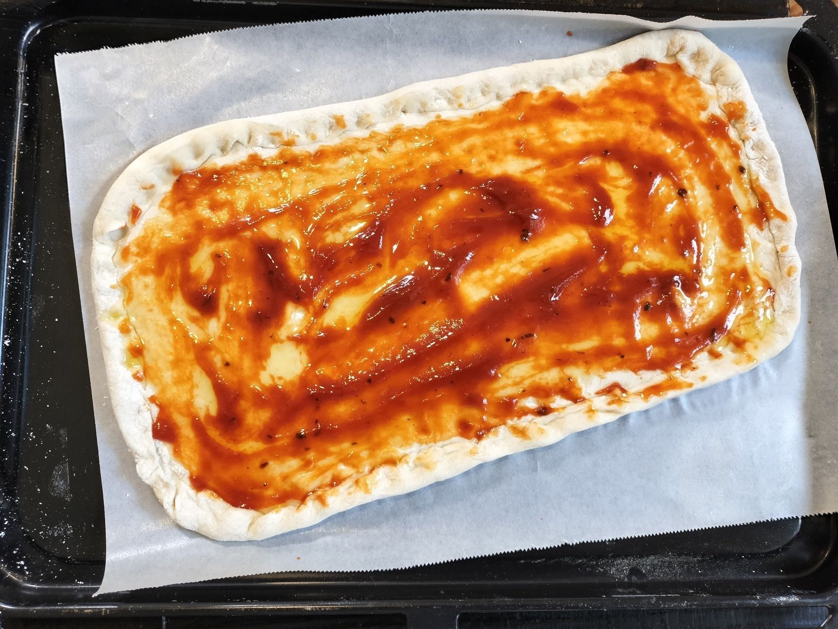 4．オリーブオイルとトマトソースを塗る