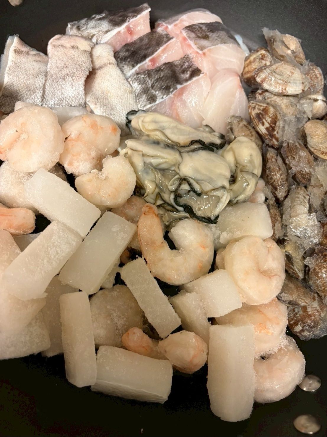 フライパンにオリーブオイルを入れて、魚介類を並べます。