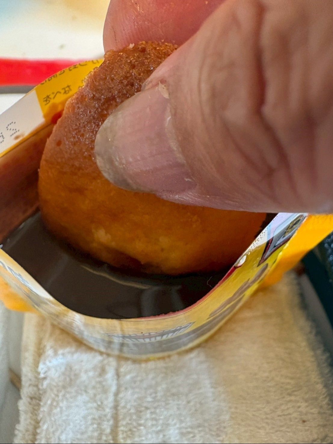 袋の上をめいっぱい切って、そのままマドレーヌを浸けてコーティングしました