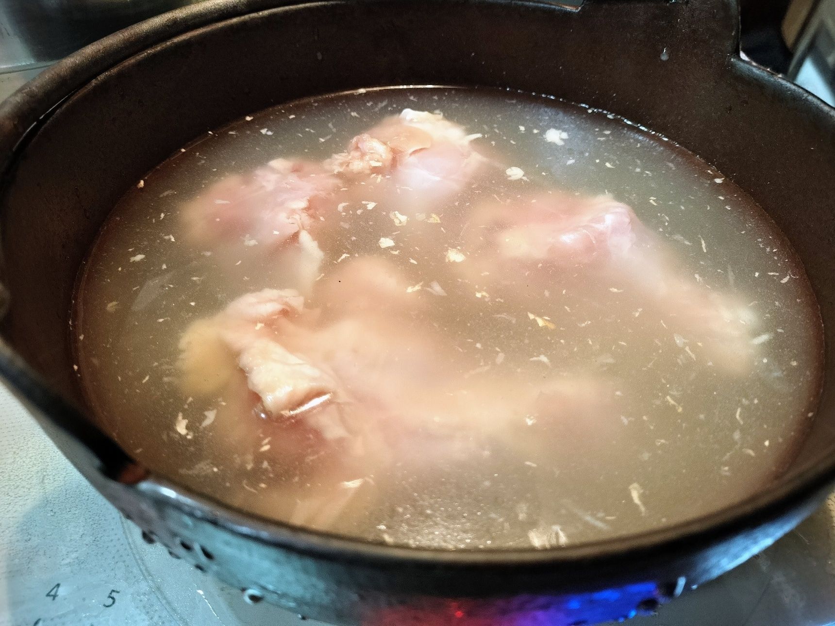 2.鉄鍋に、水と紹興酒と手順1の鶏手羽元4本を入れてひと煮立ちさせる→弱火でコトコト煮込む（45分程）