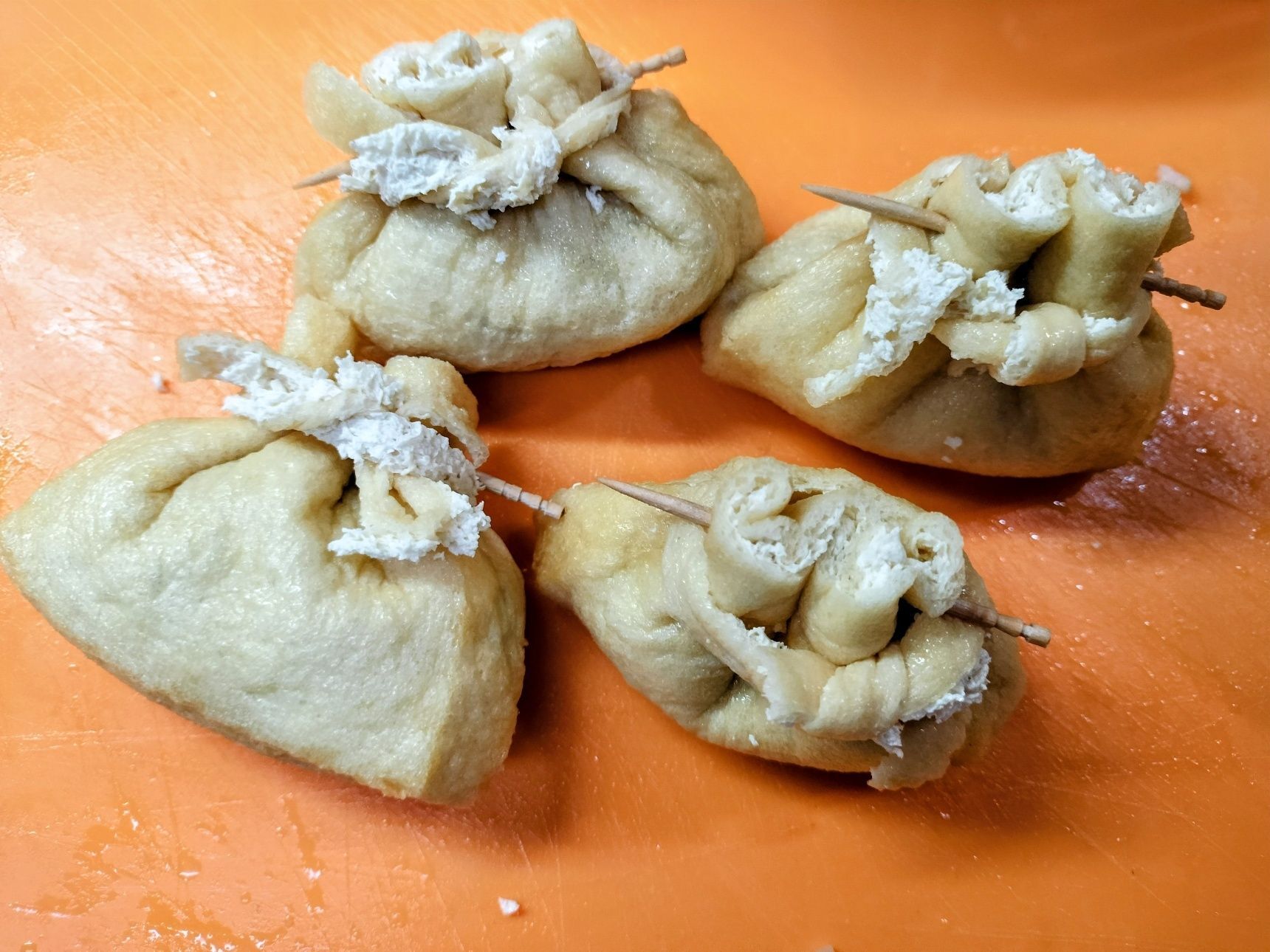 3、切った油揚げに、手順1の玄米ごはんを崩して詰める→爪楊枝で止める→細い紐状の油揚げで飾り程度に軽く結ぶ