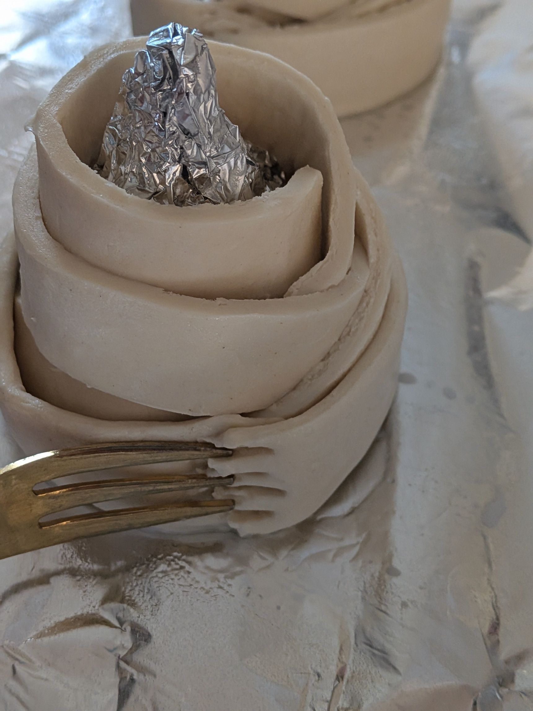 5、巻き終わりが取れないようにフォークで押さえ、くっつける。