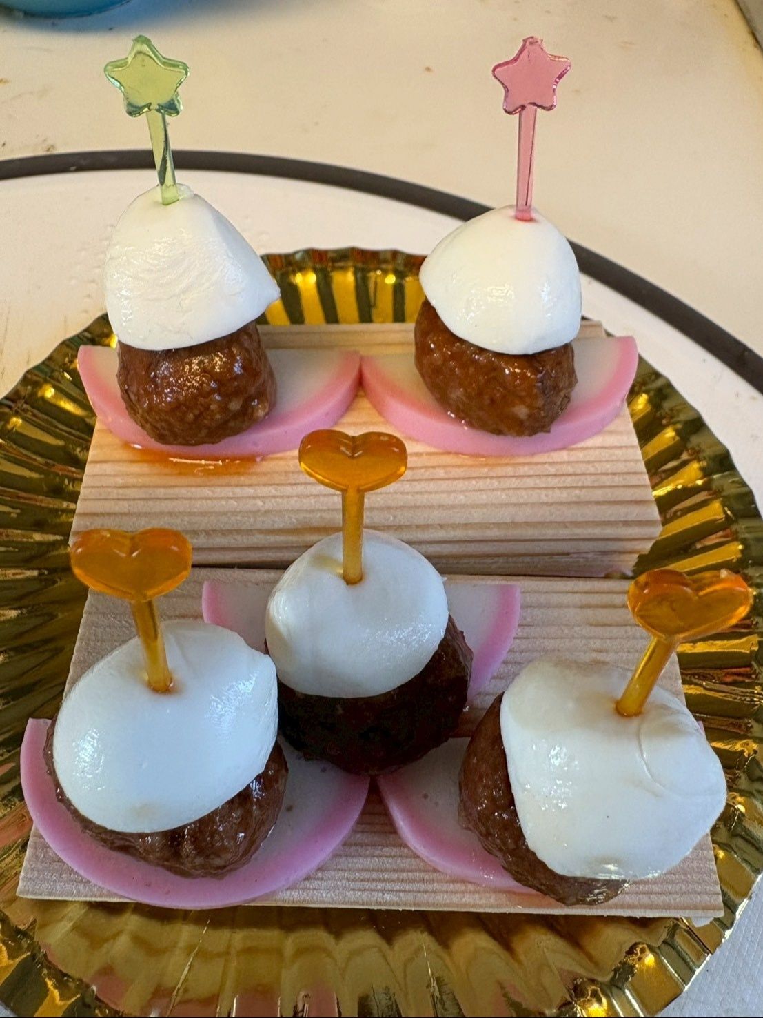 モッツァレラチーズを丁度良い大きさに切って、平らな方を下に乗せピンで留めます。