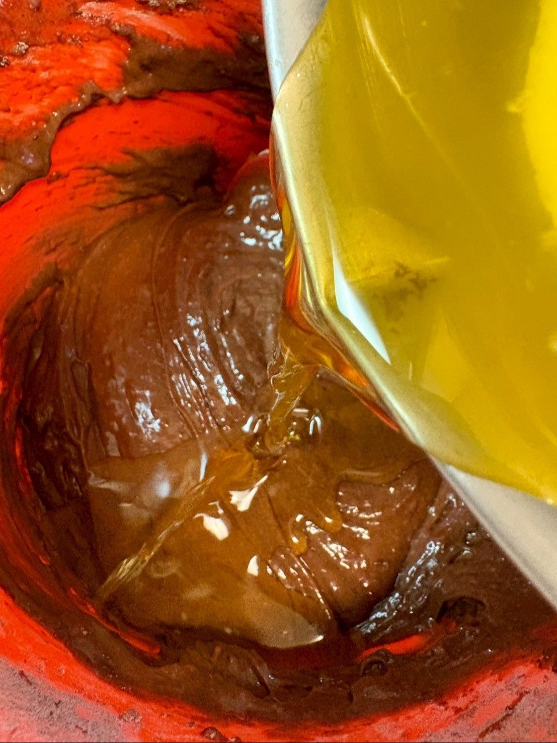 よく混ざったら、湯煎して溶かしておいたバターを少しずつ加えます。