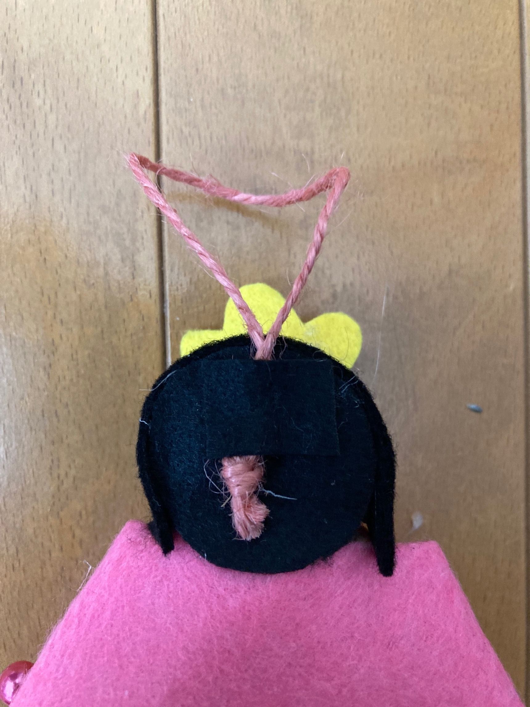 ⑥輪にした麻紐を人形の後頭部あたりに、貼り付けフェルトで押さえる。