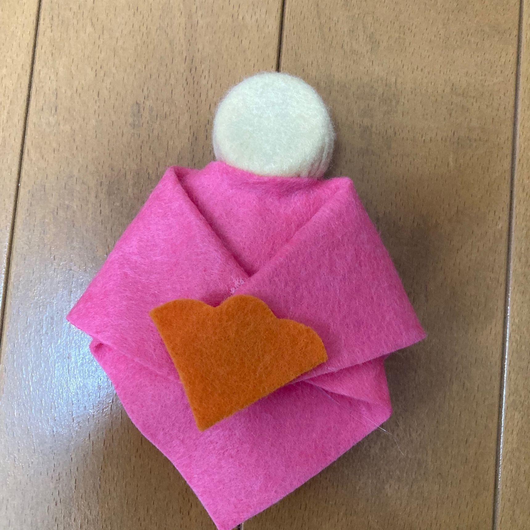 ③着物を顔の部分からかぶせ、袖を折り曲げる。