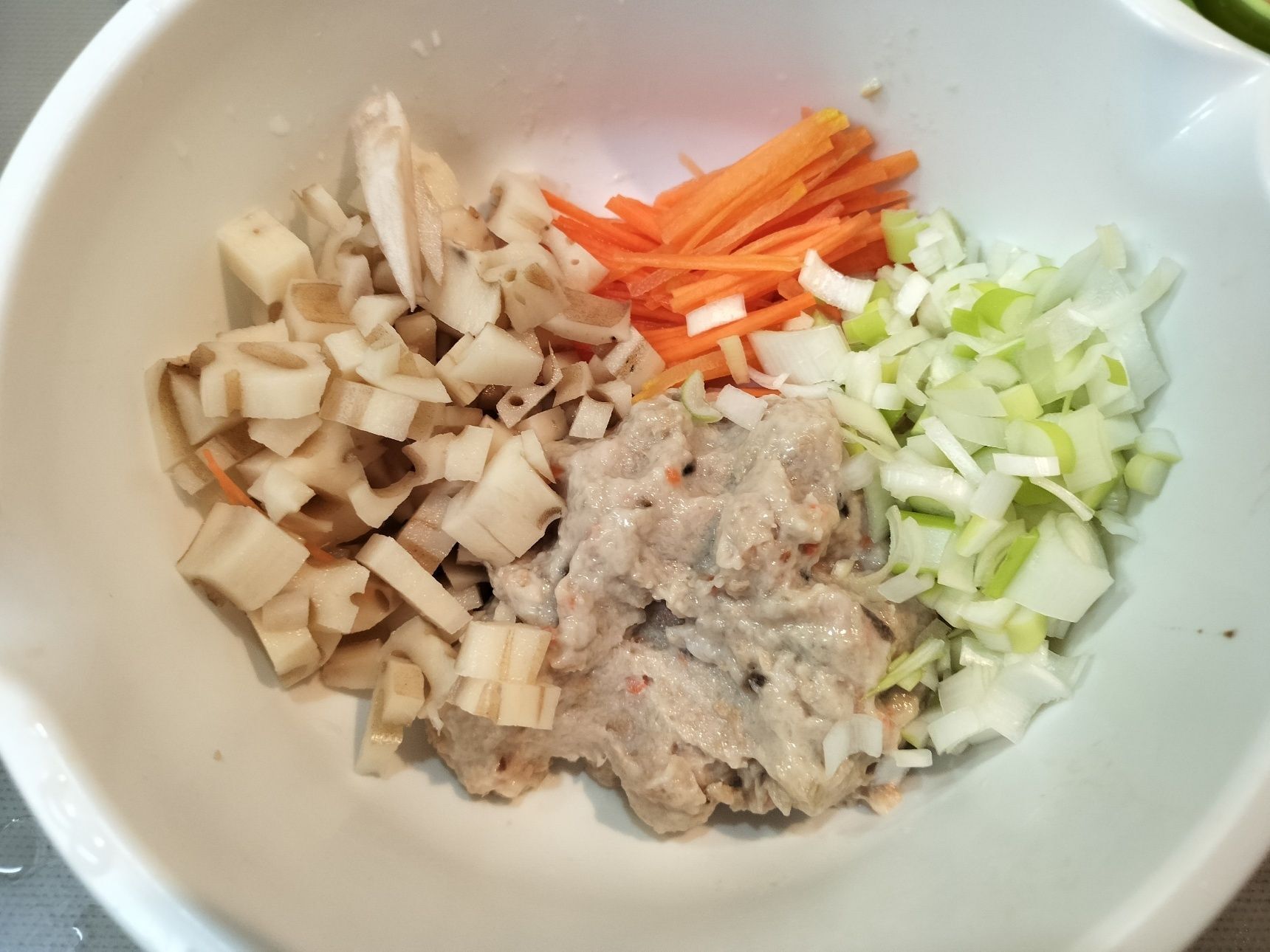 3、ニンジンを千切り、レンコンを角切り、長ネギを粗みじん切りしてボウルに入れる→鶏ごぼうすり身を加えて混ぜる