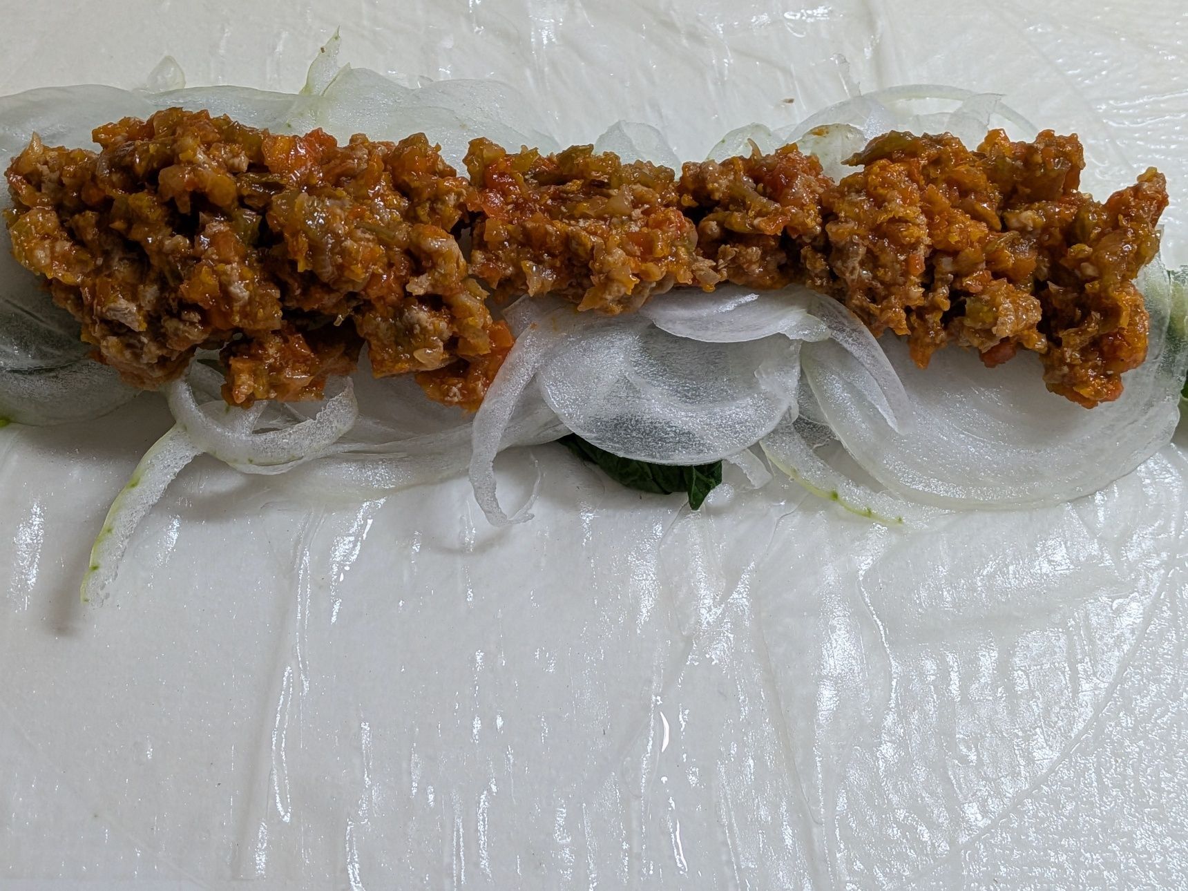 3.ライスペーパーを水に濡らし、菜の花、新たまねぎ、ミートソースの順にのせ、手前から巻く