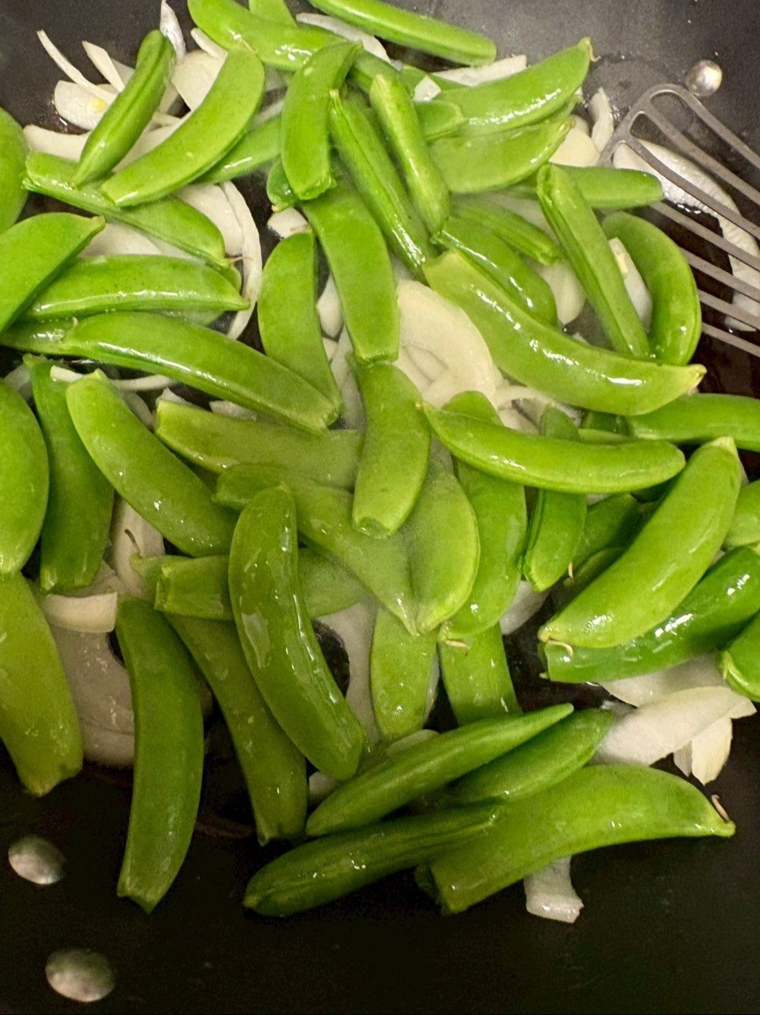 ヘタを取ってサッと洗ったスナップエンドウを加えます。