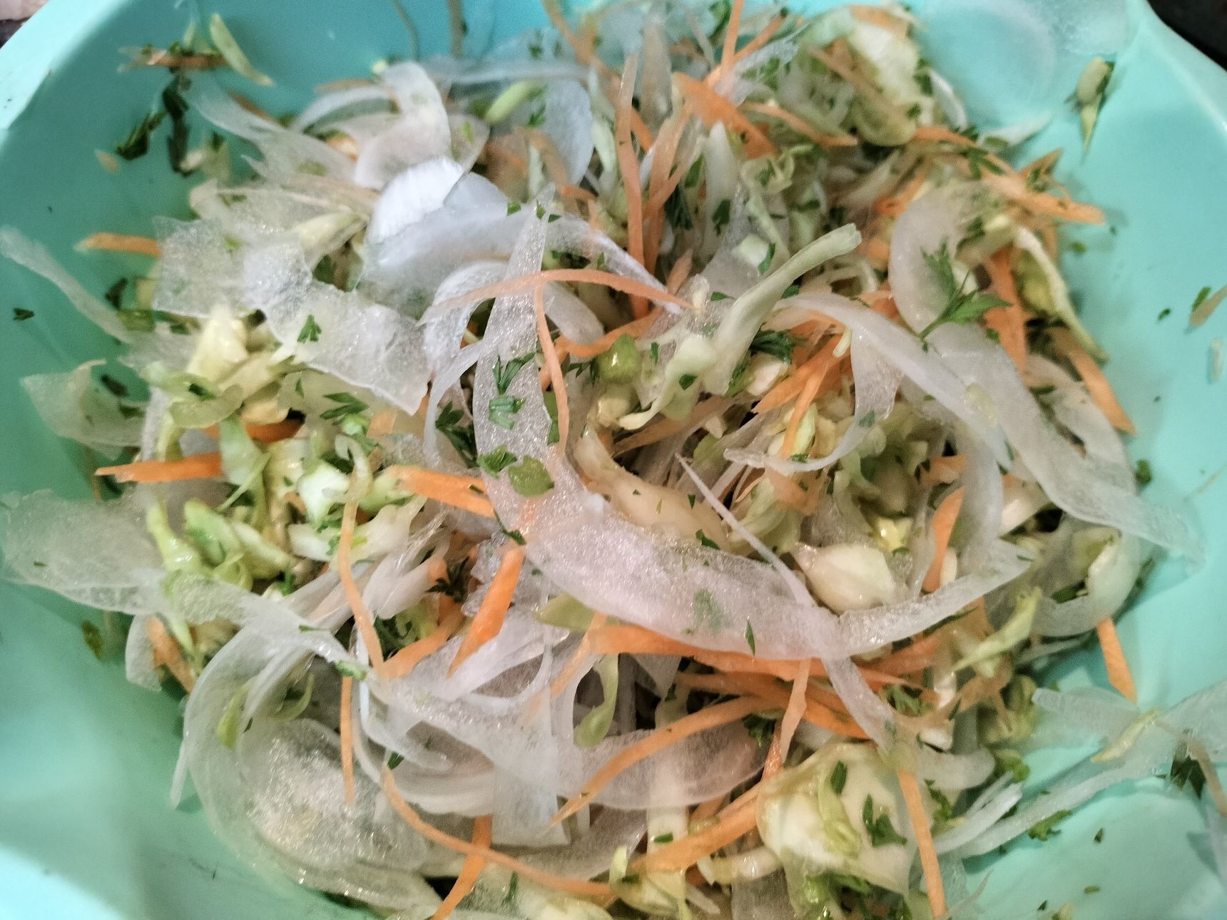 2、キャベツと人参は千切りする→人参の葉はみじん切りする→新玉ねぎは、スライサーで薄切りして、サッと水にさらし、水気をしっかり絞り、更にキッチンペーパーで水気を拭き取る→切った野菜を混ぜ合わせる→器に野菜を入れる→無塩せきベーコンをバラに見立ててクルクル巻いて盛り付け、人参の葉を添える