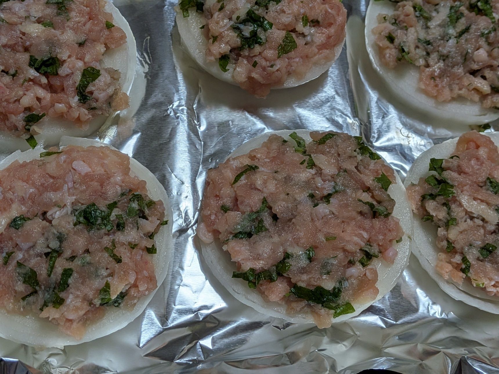 2、新たまねぎを1センチ厚さくらいの輪切りにする。トースターの天板にアルミホイルをしき、新たまねぎを置く。工程1を新たまねぎの上に均等にのせて広げる。