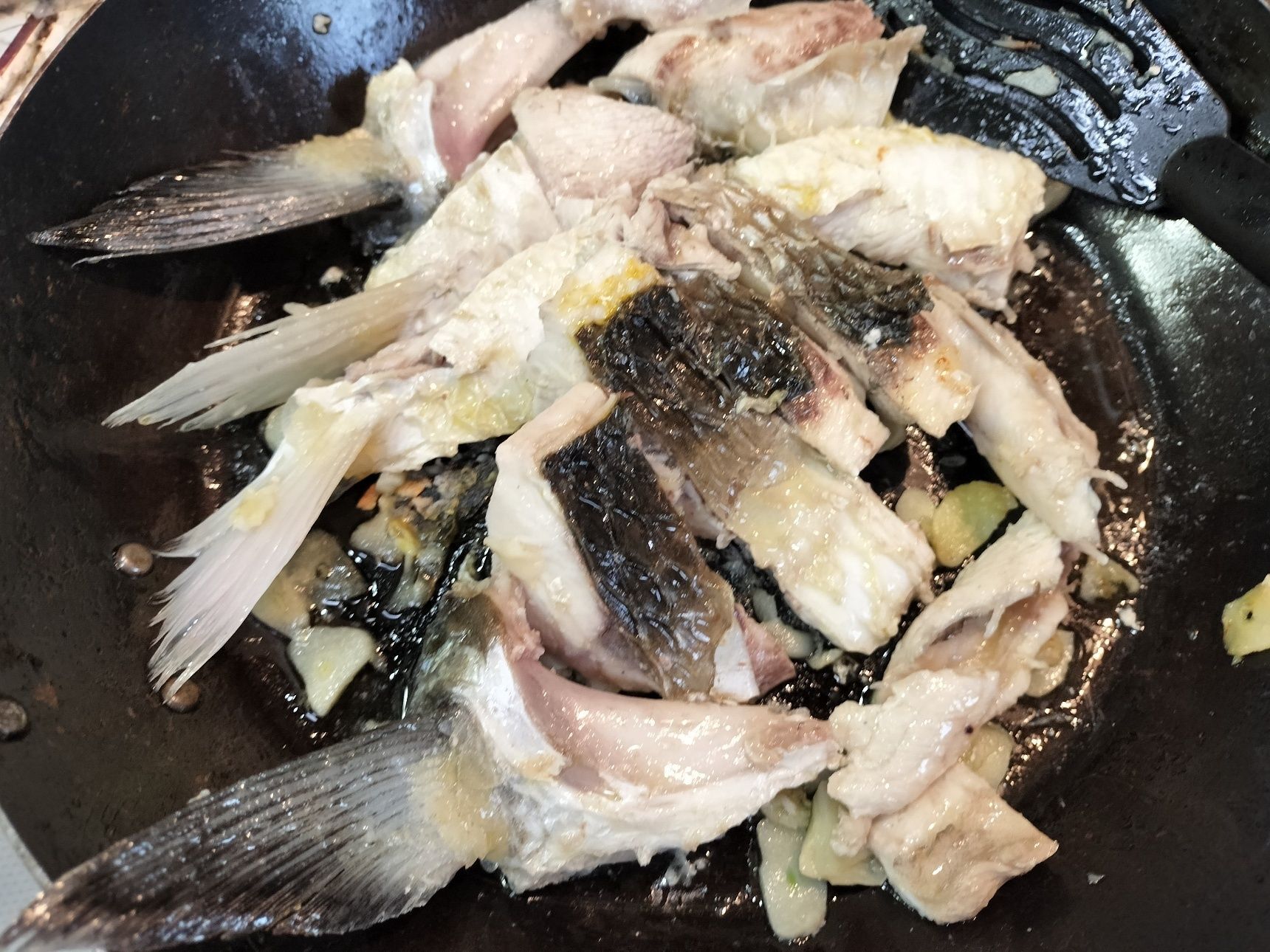 5.フライパンに、オリーブオイルとにんにくを入れ中火にかける→にんにくの香りが出てきたら、手順2のボラの両面を焼く→手順3の濾したアラ出汁と中落ち肉を加える