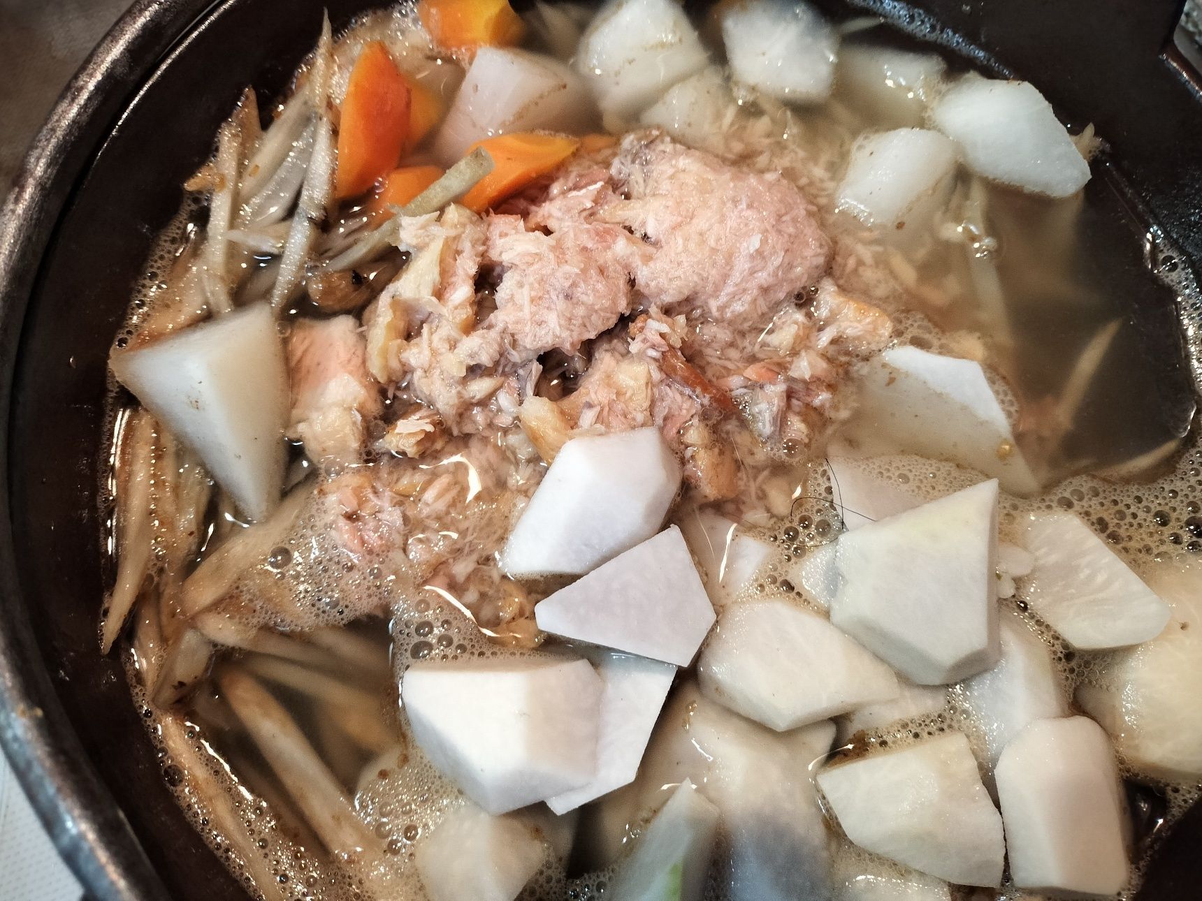 1. 鉄鍋に、ごま油を入れて熱し、材料●を入れて炒める→水とほぐした焼鮭を加えて、ひと煮立ちさせる→弱火〜中火で20分程煮る