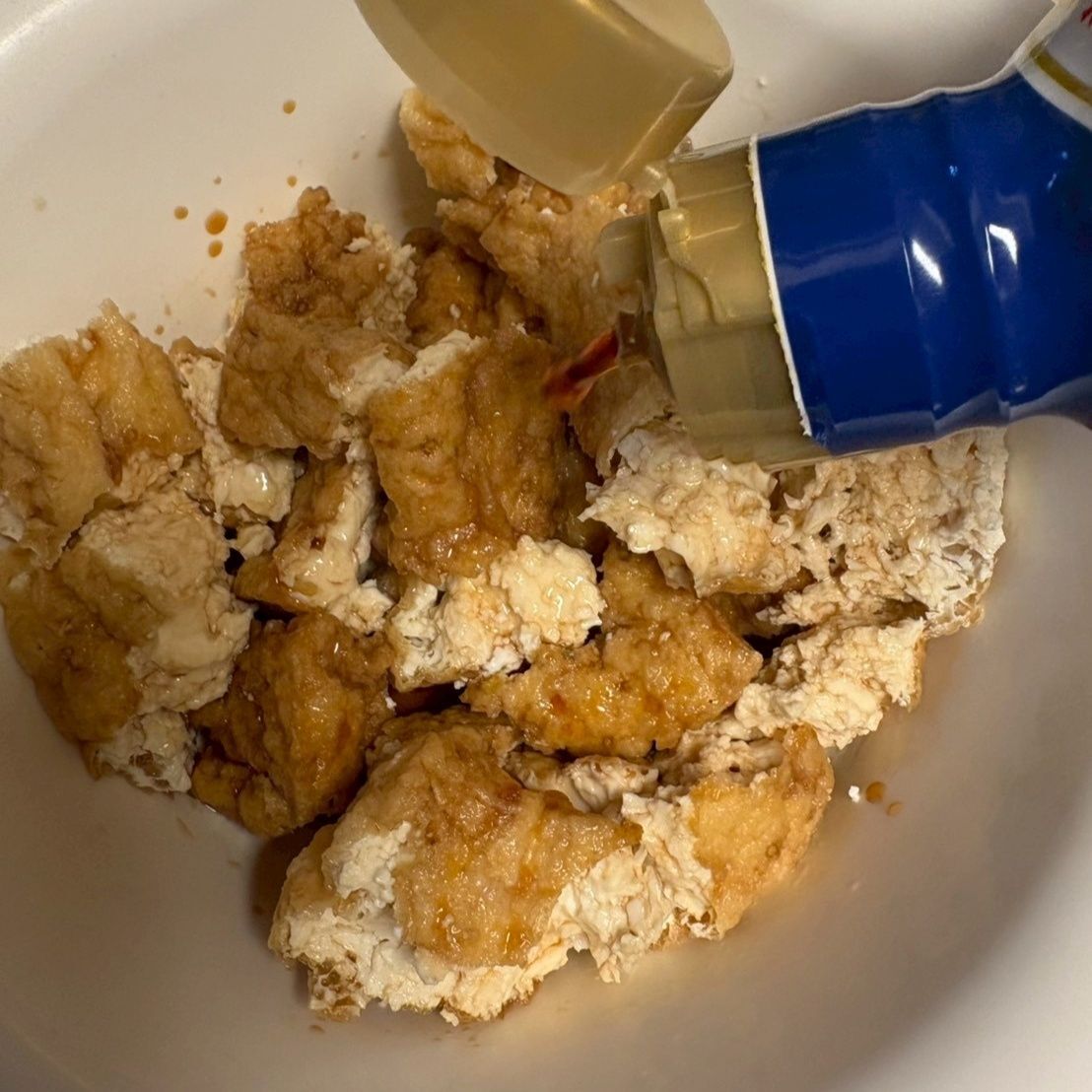 厚揚げを手でちぎって、醤油、みりん、生姜の擦り下ろしを加えます。