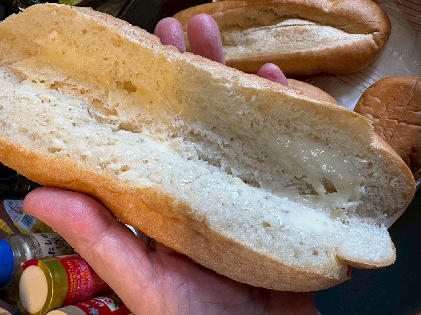 ソフトフランスパンの真ん中を切ってバターを塗ります。