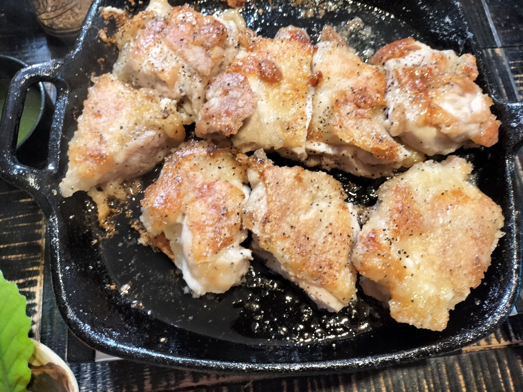 熱々の鉄フライパンごと食卓へ〜！食べやすい大きさに切る→熱々、表面カリッと中しっとり柔らかに焼き上げた鶏もも肉に、赤唐辛子にんにくと小ネギをのせて、いただきまーす！