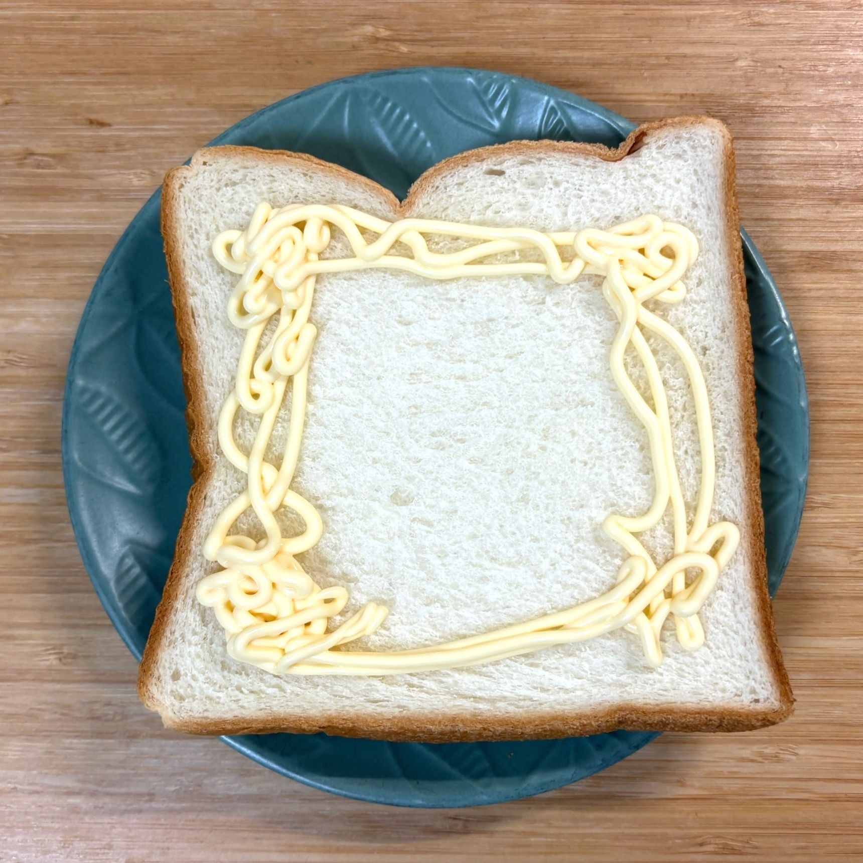 食パンのフチにマヨネーズを一周させます