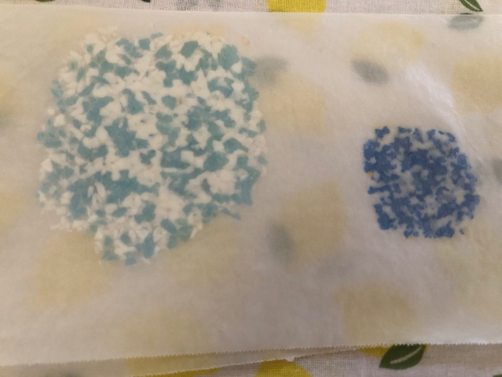 刻んだペットボトルキャップをクッキングシートで挟みます