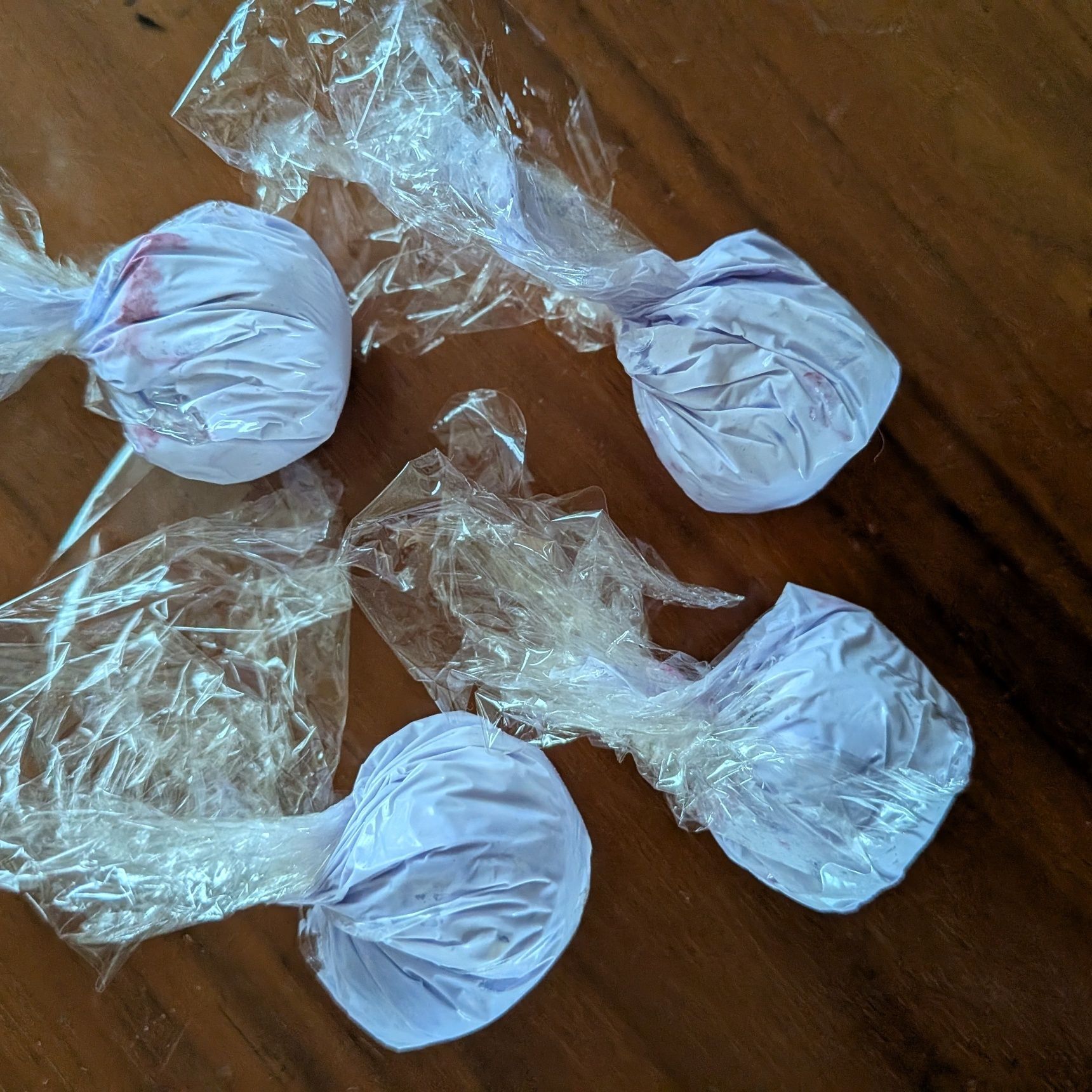 1. 冷凍生クリームに食品着色料をいれてよく混ぜ、紫色のクリームを作る。真ん中にブルーベリーを一粒いれてラップで丸める。4つ作る。