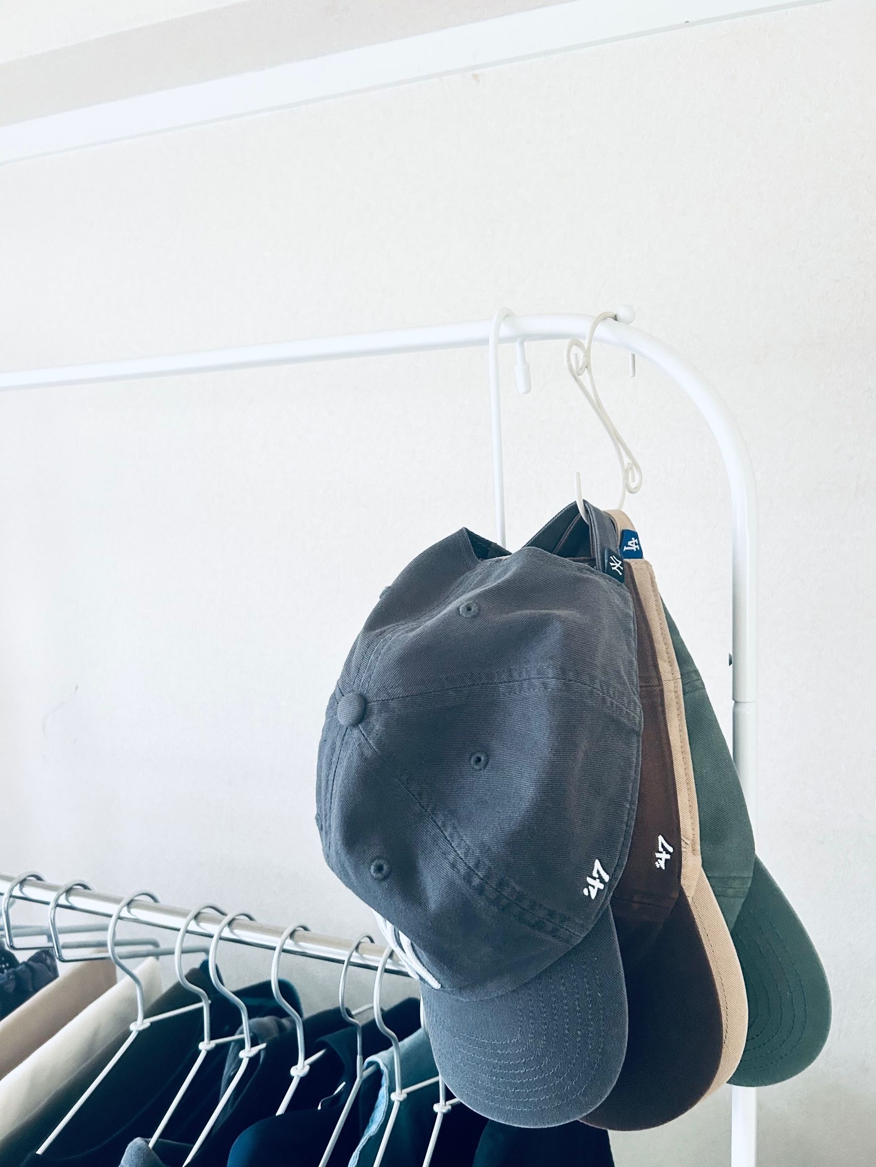 洋服ラックの滑り止めにキャップ用のフックを掛けて。