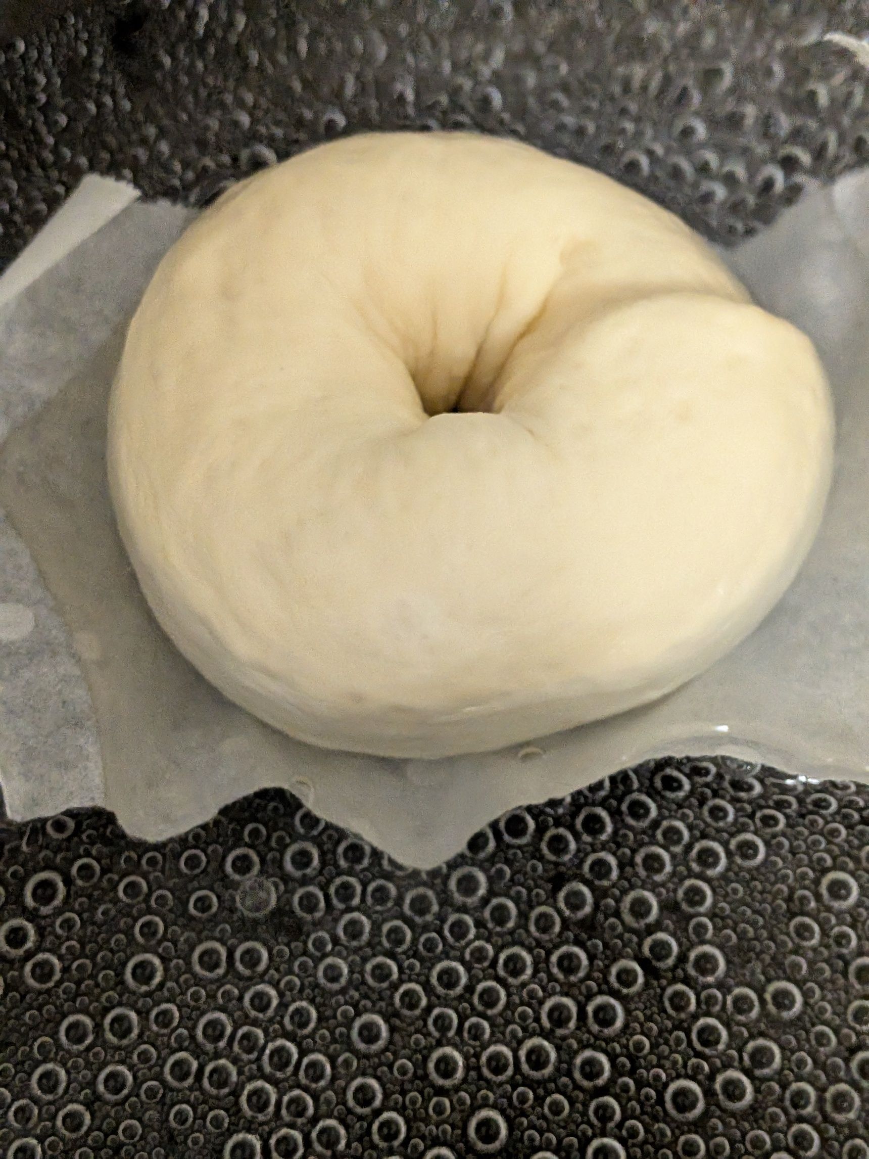 2、フライパンにお湯を入れ（分量外）ベーグルを1分茹でる。ひっくり返して軽く茹で、すぐに200℃のオーブンに入れる。