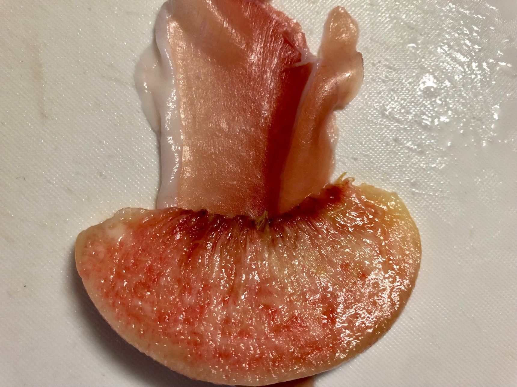 生ハムを半分に切り、生ハムの上に桃を載せてくるっと巻きます