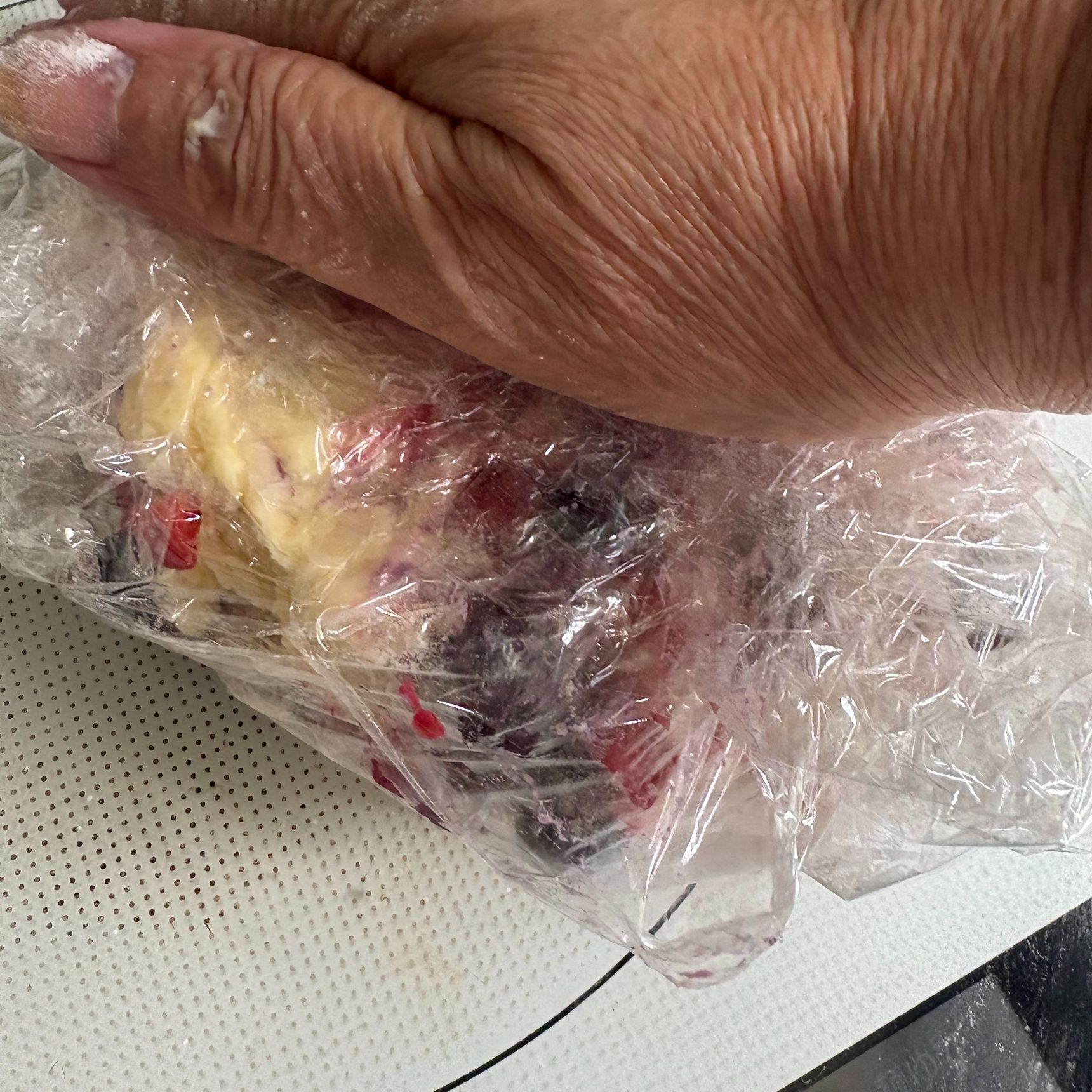 打ち粉をしたラップの上にお団子2つくらいを重ね、上からおさえて丸くします。