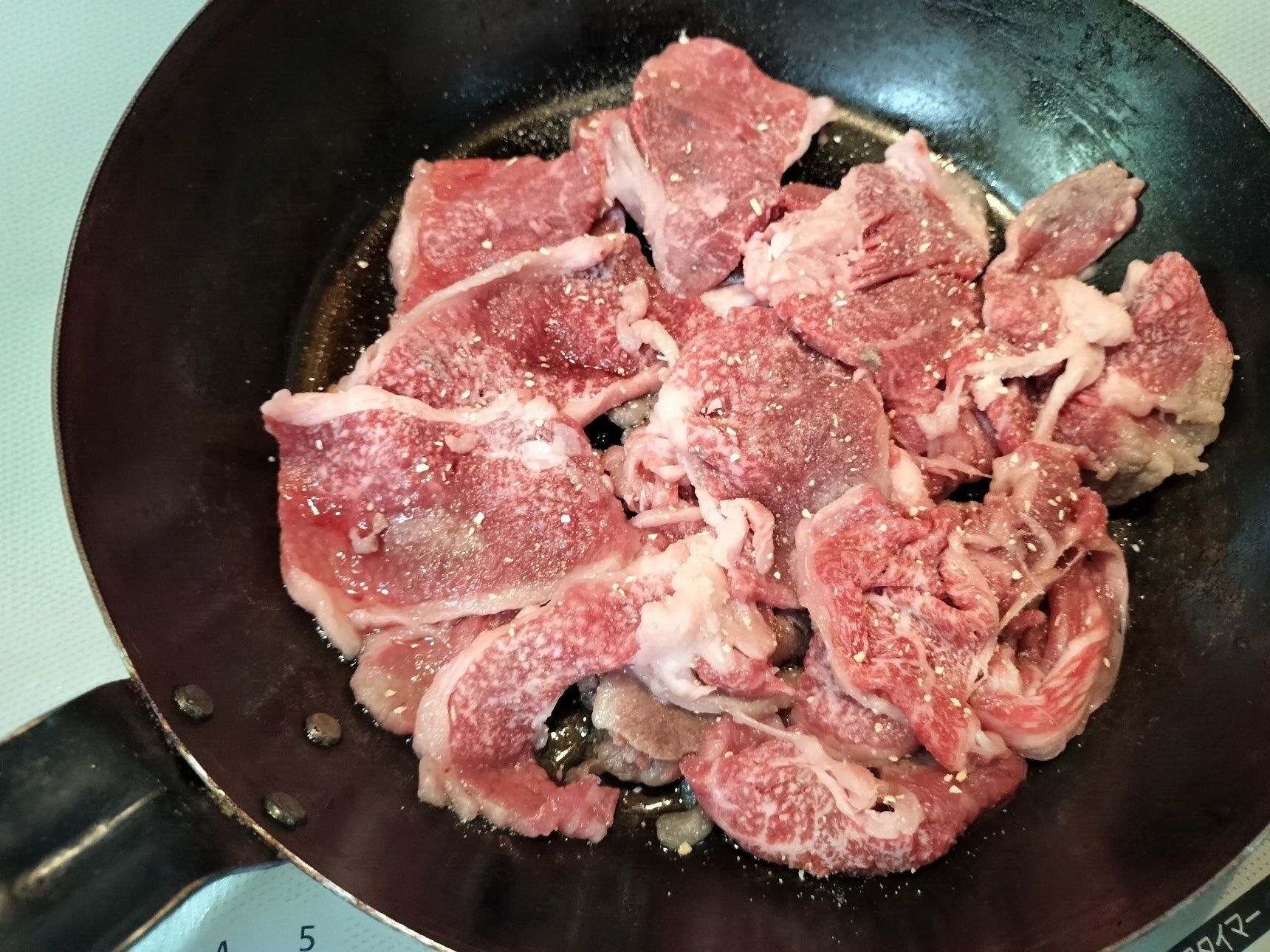 2. 鉄フライパンを熱し、ごま油を入れる。牛肉ににんにく塩をふりかけてサッと焼き、一旦、皿に取り出す。