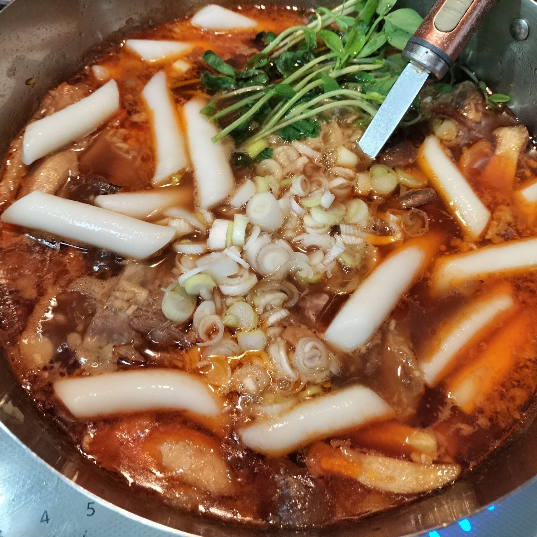 4、手順1のトッポギ餅を入れる→弱火で餅が柔らかくなるまで煮る→豆苗と長ネギを添える
