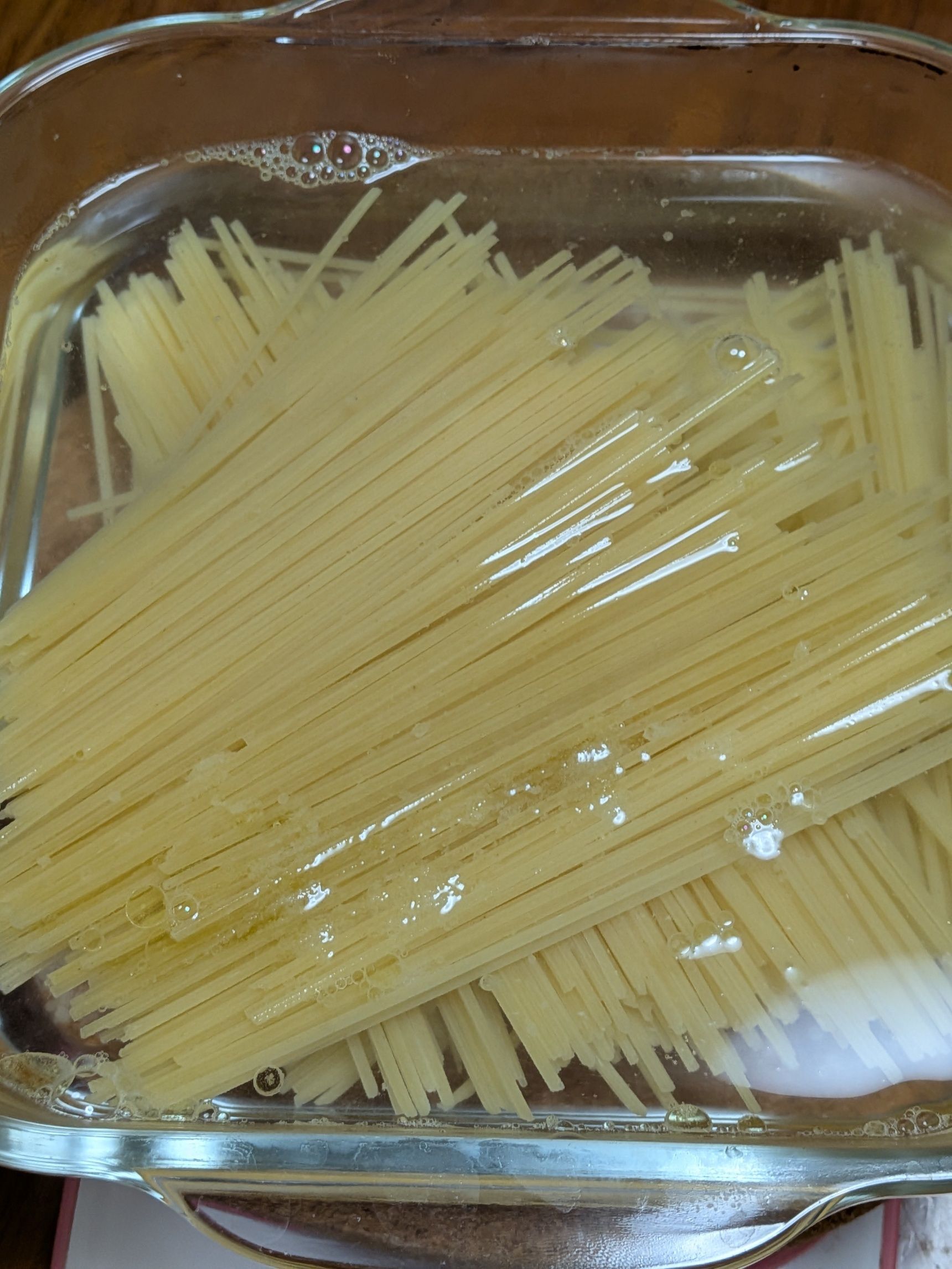 1、スパゲッティは半分の長さに折り、耐熱容器に交差するようにいれる（写真参考）。