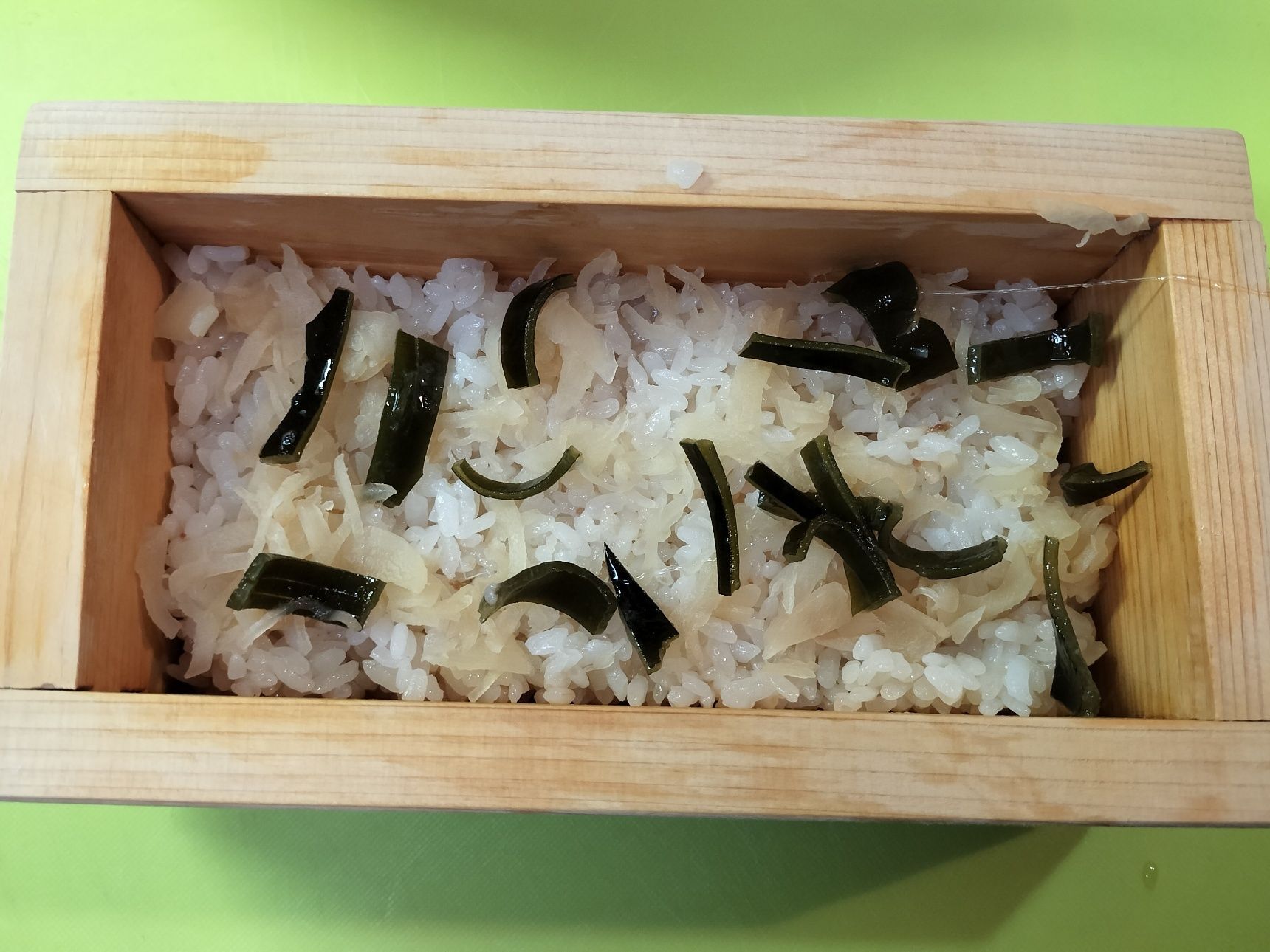 4、押し寿司器に、酢飯を詰める→切った昆布と新生姜の甘酢漬けを散らす→鯵の昆布甘酢漬けをのせる