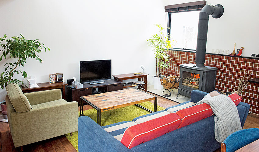 薪ストーブをソファーやラグで囲んだリビング
