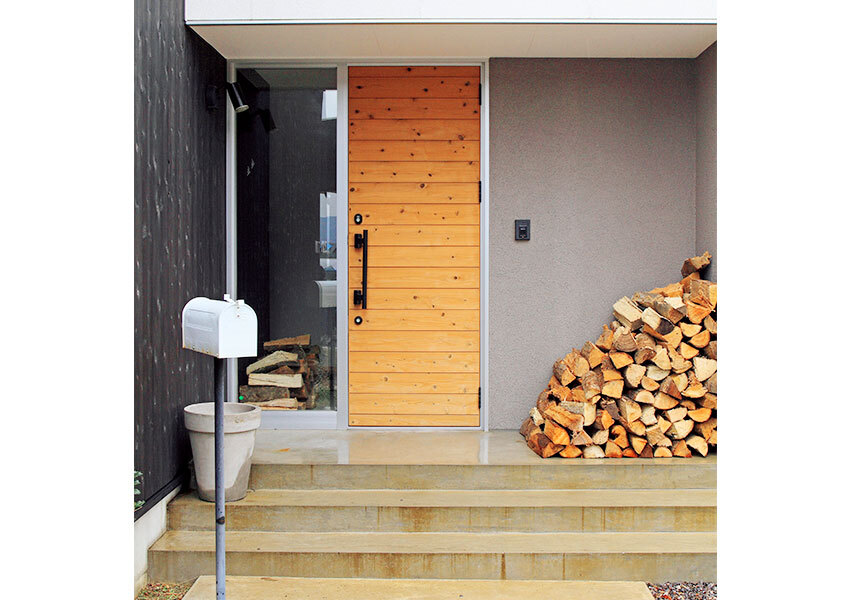 木製ドアが映えるシンプルな玄関