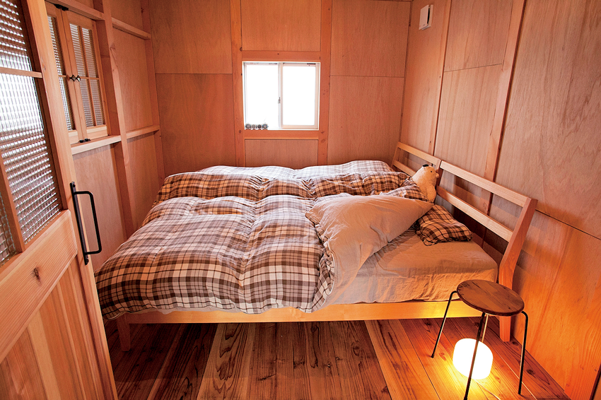 木に囲まれたコンパクトな寝室