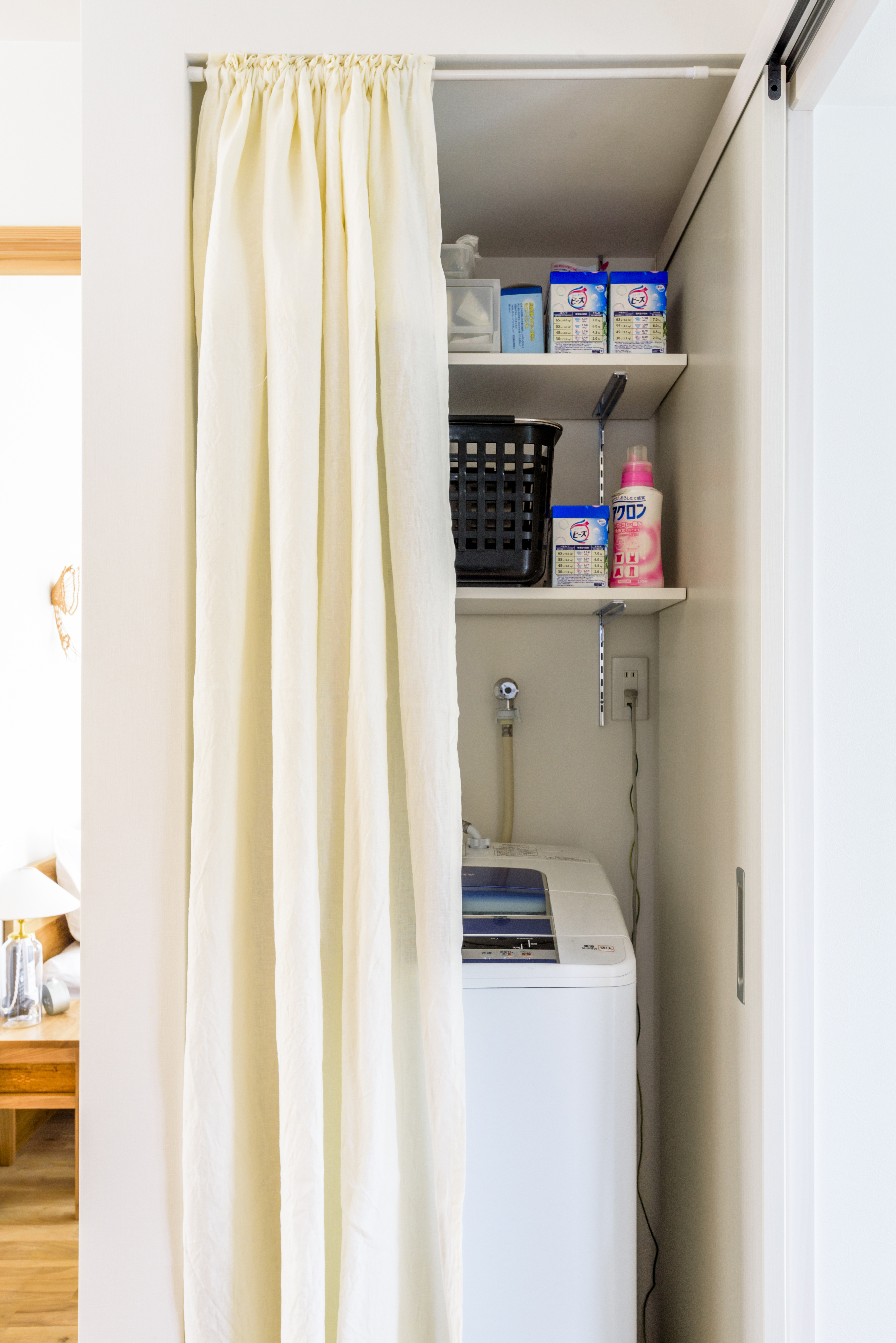 カーテンで目隠しされた洗濯機