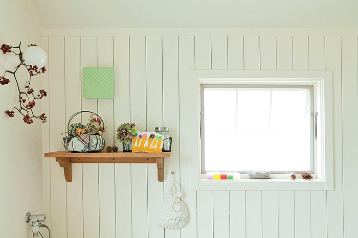 一面を白い板張りにした洗面室の壁