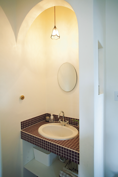 ボルドー色のモザイクタイルが印象的な手洗いコーナー