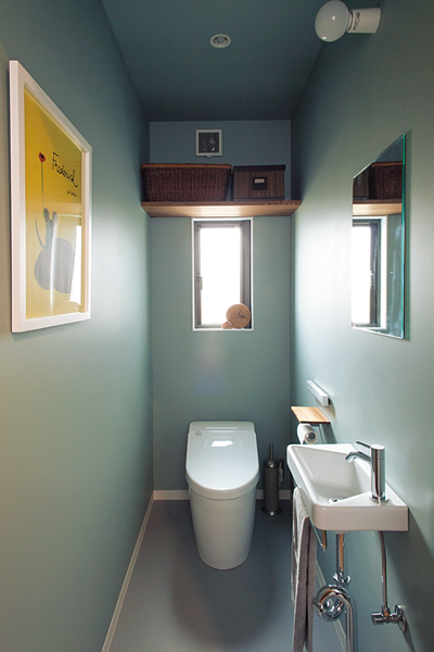 ブルーグレーの壁紙のトイレ