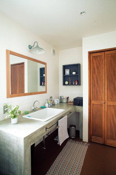 モルタル塗りの洗面台がある洗面室